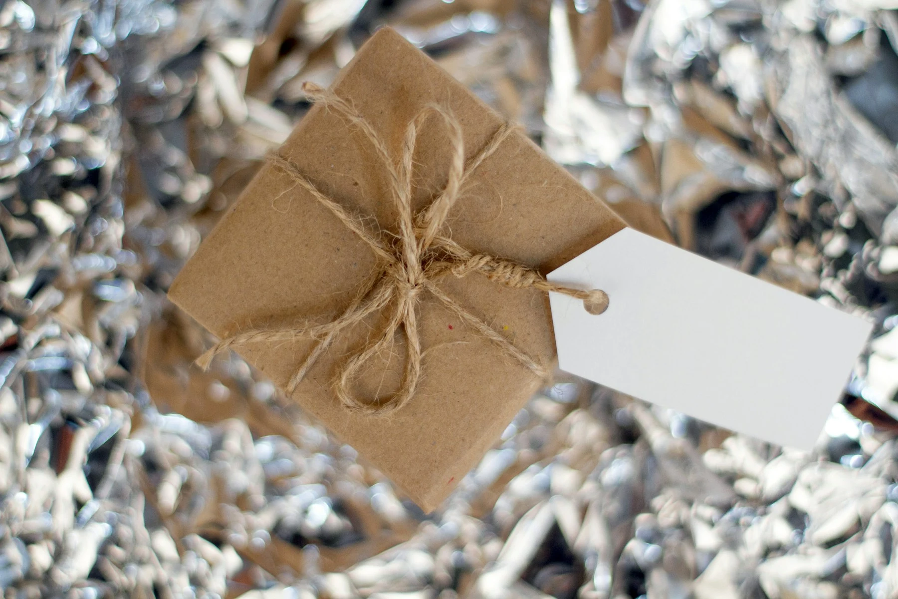 Geschenke in braunem Papier auf einem Holztisch